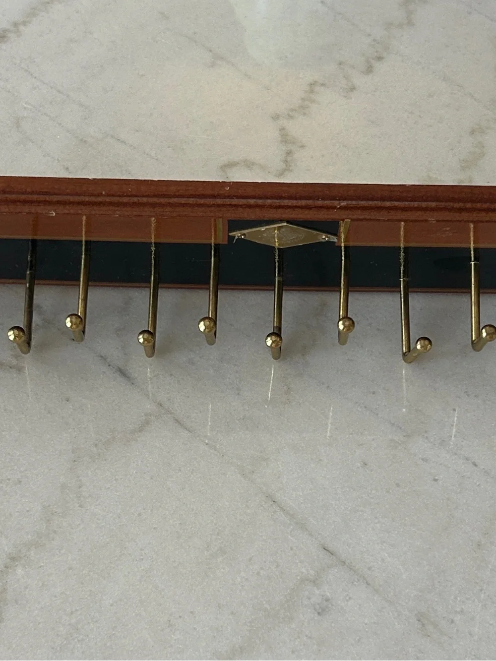 Vintage Wall-Mounted Tie Rack with Gold Hooks and Black Accent